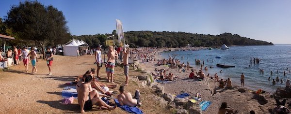 Outlook 2011 13018 A sandy beach with many people on the sand walking or laying down and some in the water